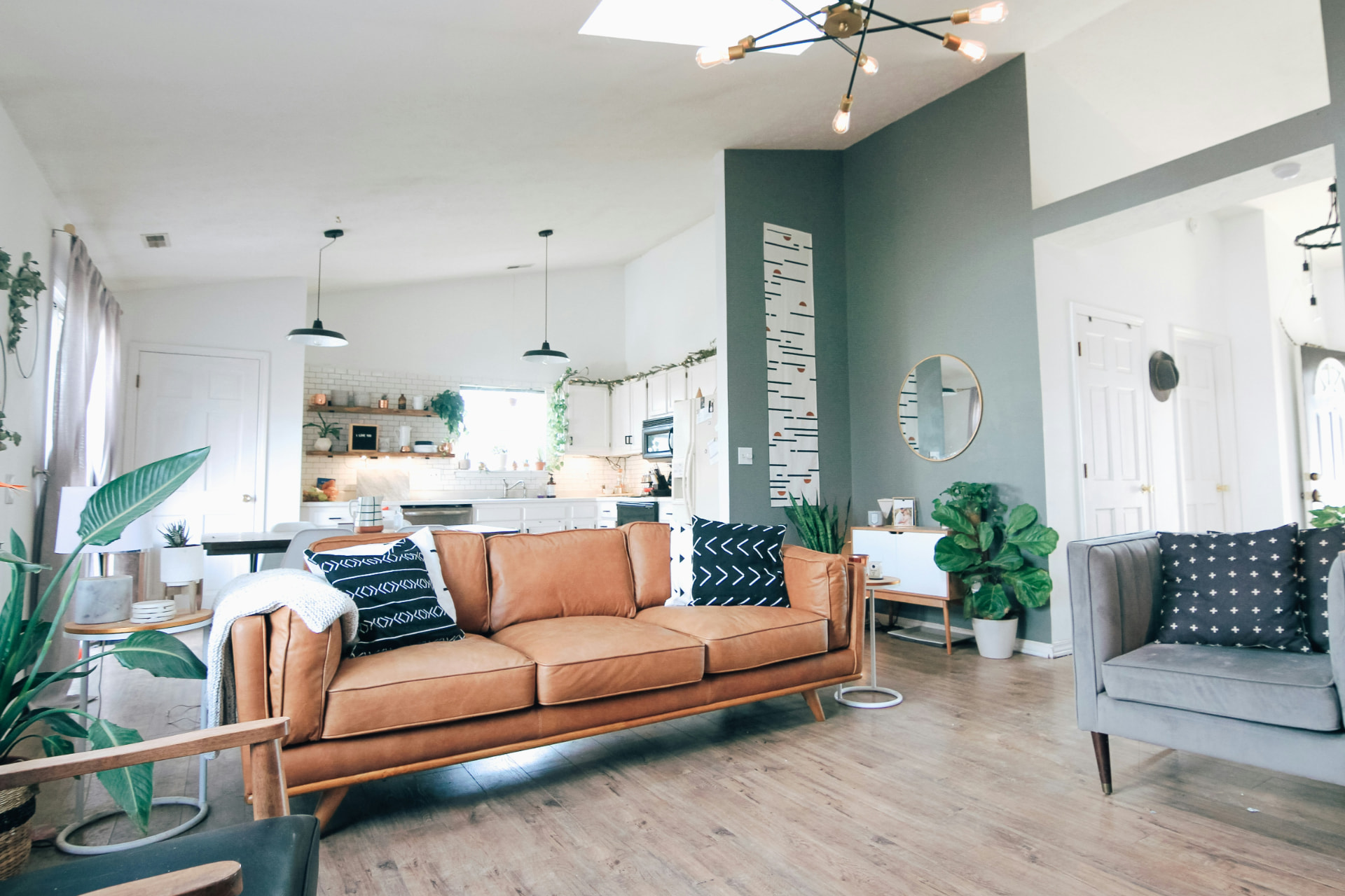 Bright, freshly cleaned living room with a cream sofa, warm wood floors and large windows